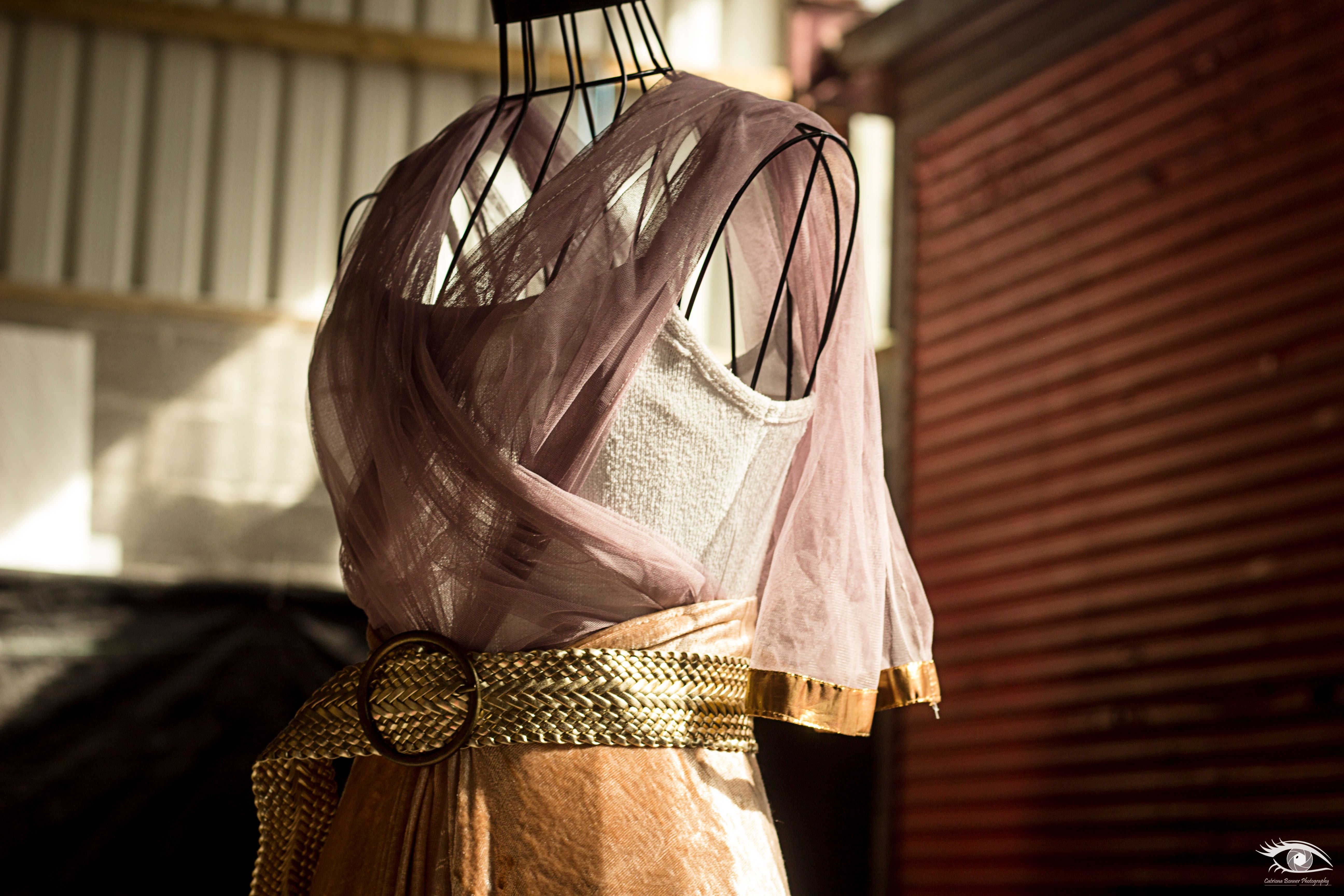 a wire frame mannequin draped in fabrics